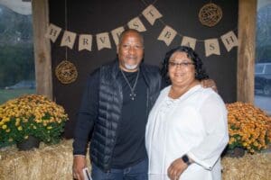 Photo of two people at the Harvest Bash standing in front of bails of hay