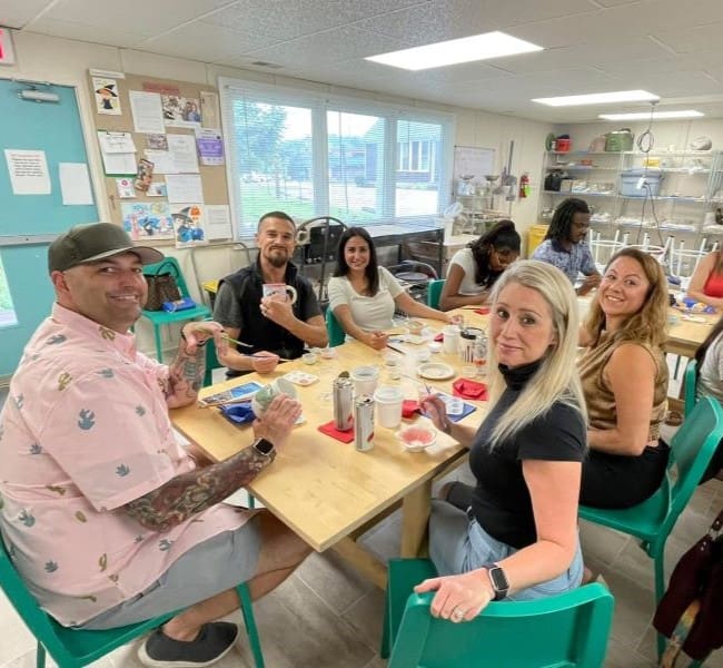 People sitting at table at a pottery class